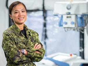 Cdr Nguyen in uniform in front of imaging equipment