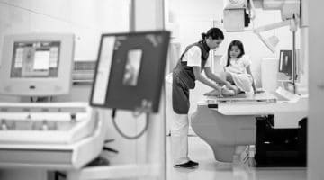 A technician preparing a child patient for a medical imaging procedure
